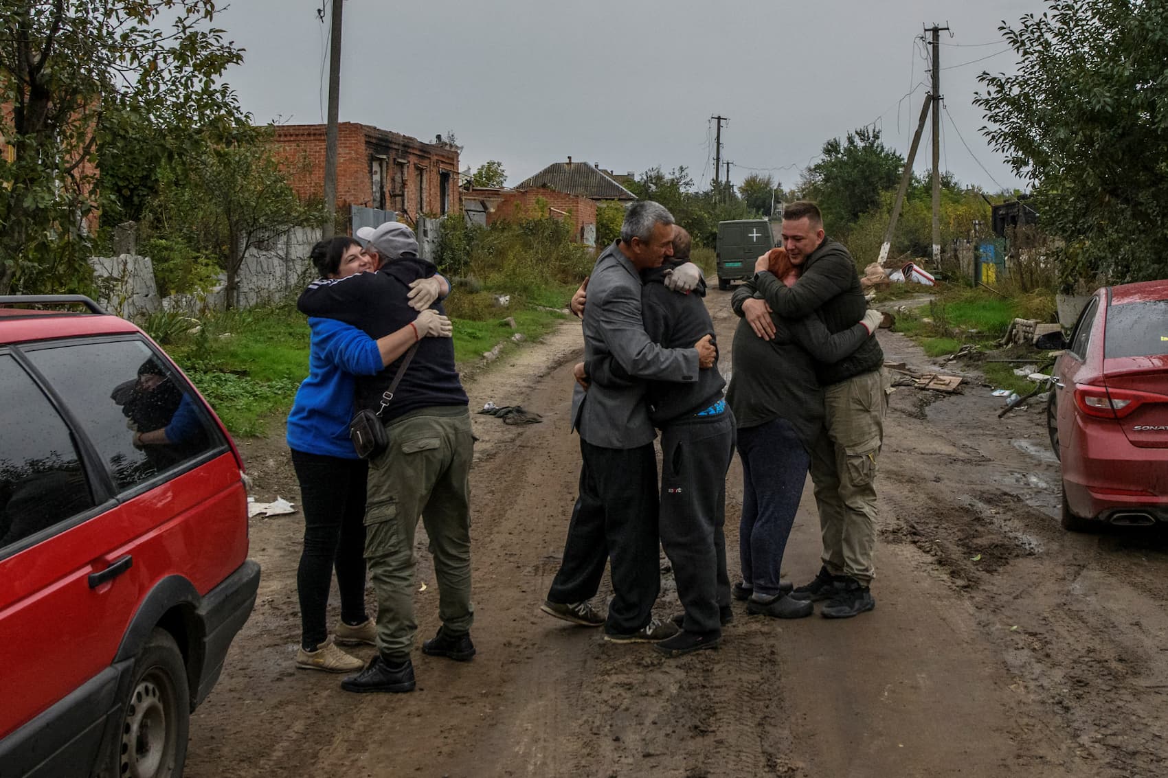 Vizinhos abraçam-se no regresso a casa em Kamianka, na região de Kharkiv