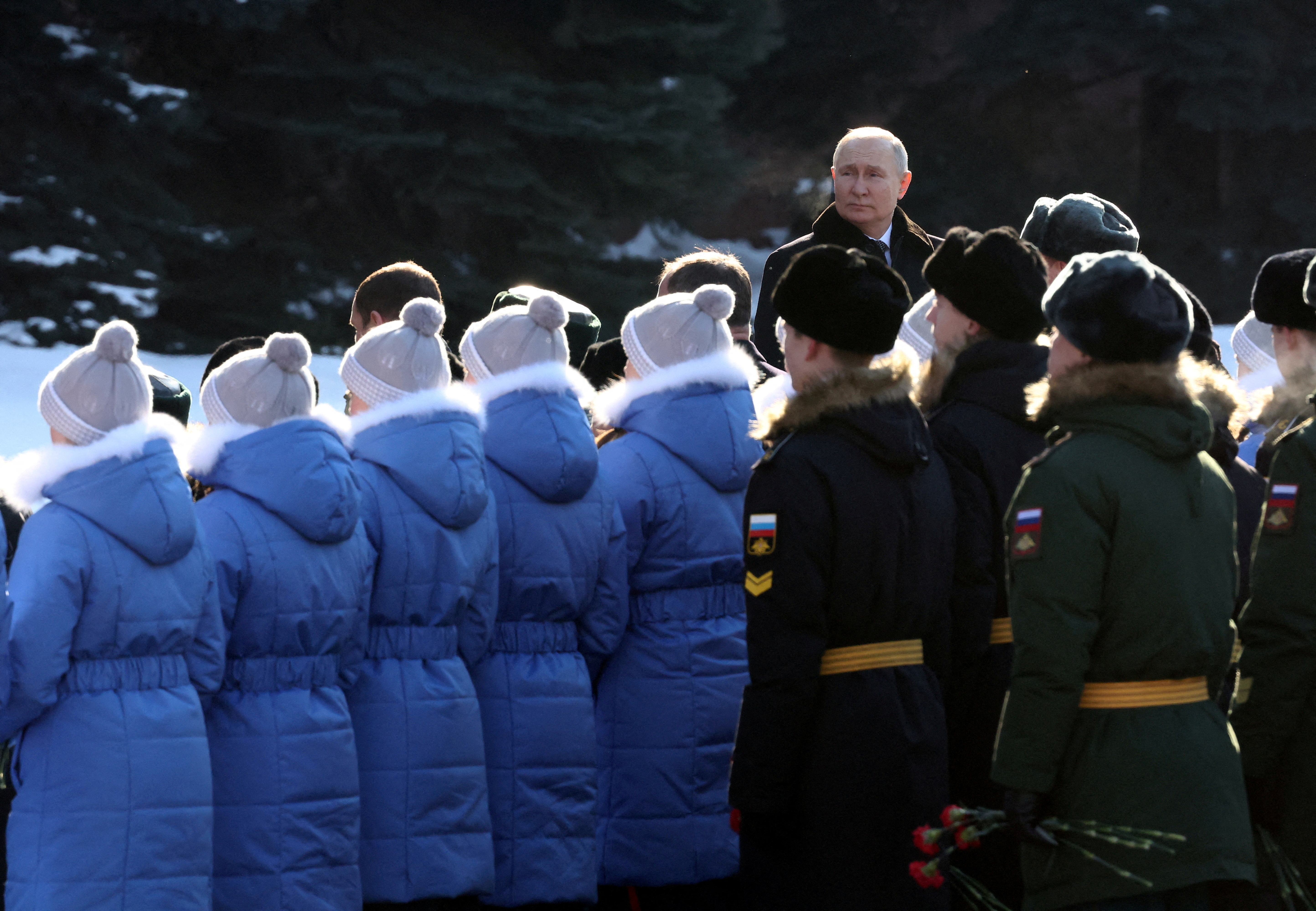 Grupo de pessoas que costas a ser observado por Vladimir Putin