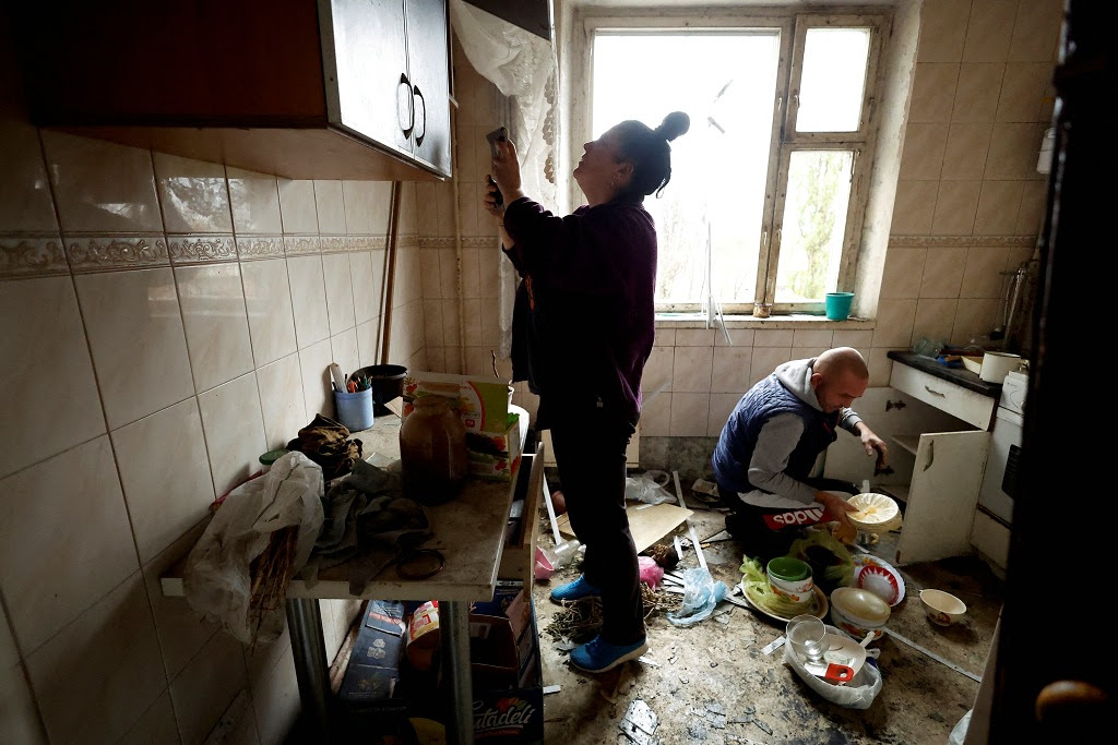 Casal no interior da sua casa, em Kharkiv, danificada por bombardeamento russo