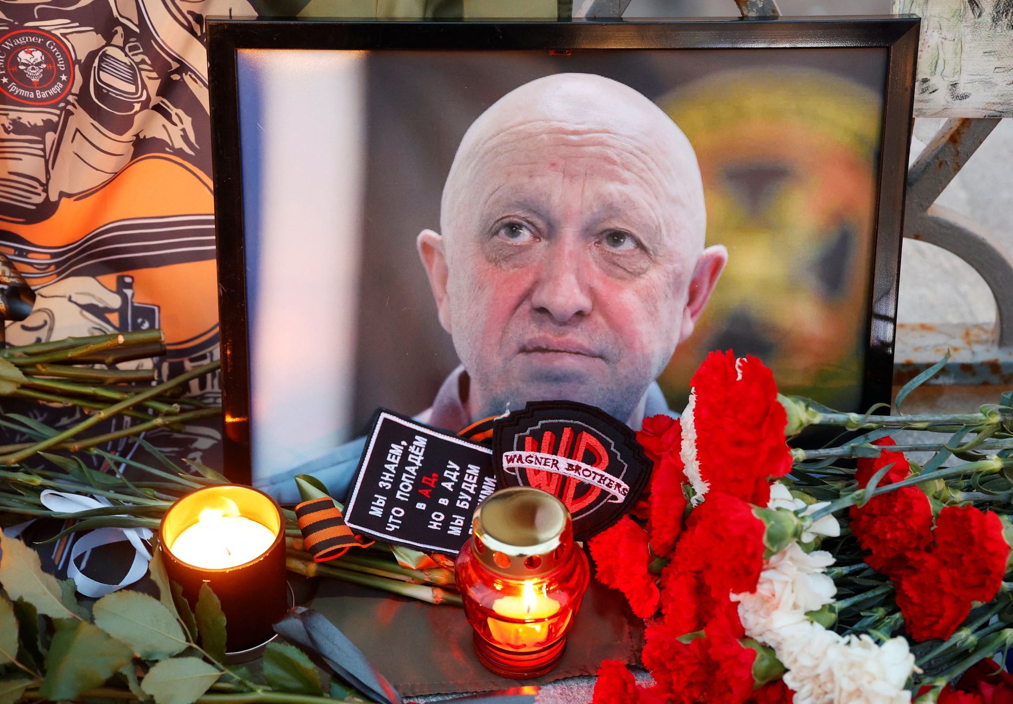 Moldura com foto de Yevgeny Prigozhin, rodeada de velas e flores